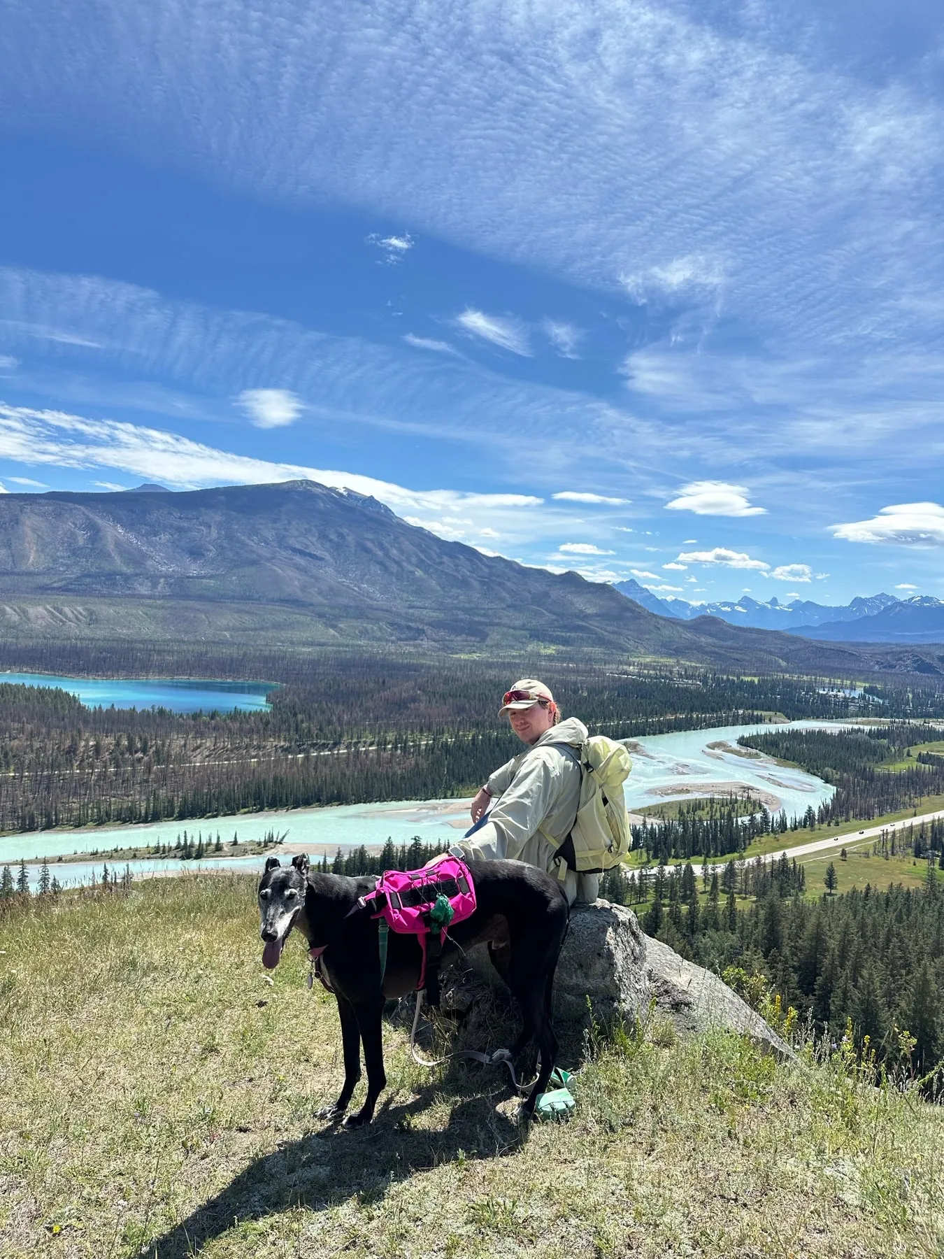 Marcell and Benji overlooking a mountain valley and turquoise river