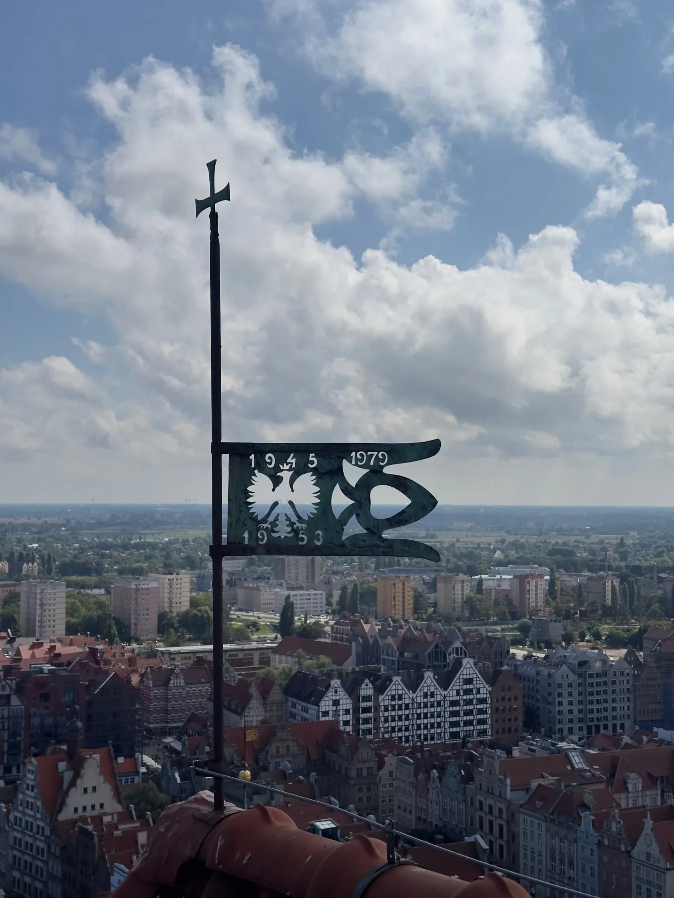 Historic Polish eagle sign above the rooftops of Gdańsk