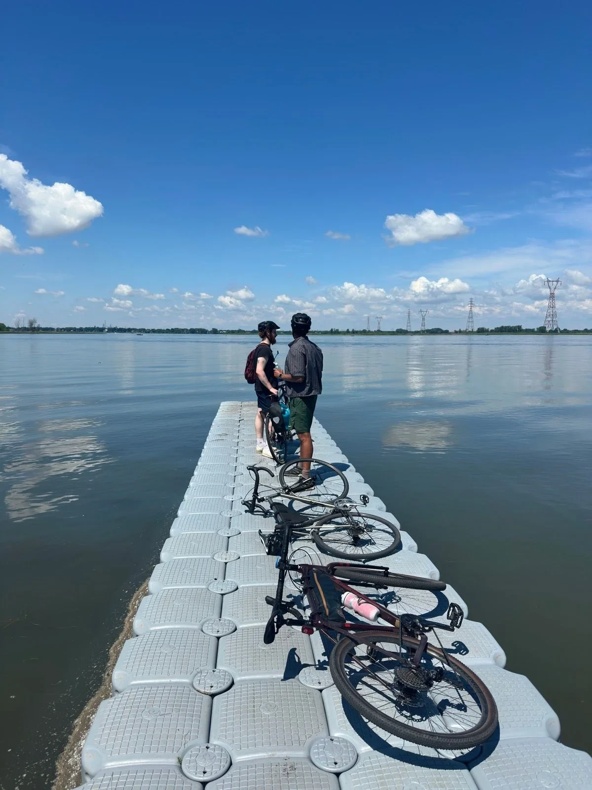 Two loaded bicycles parked on a dock by the water